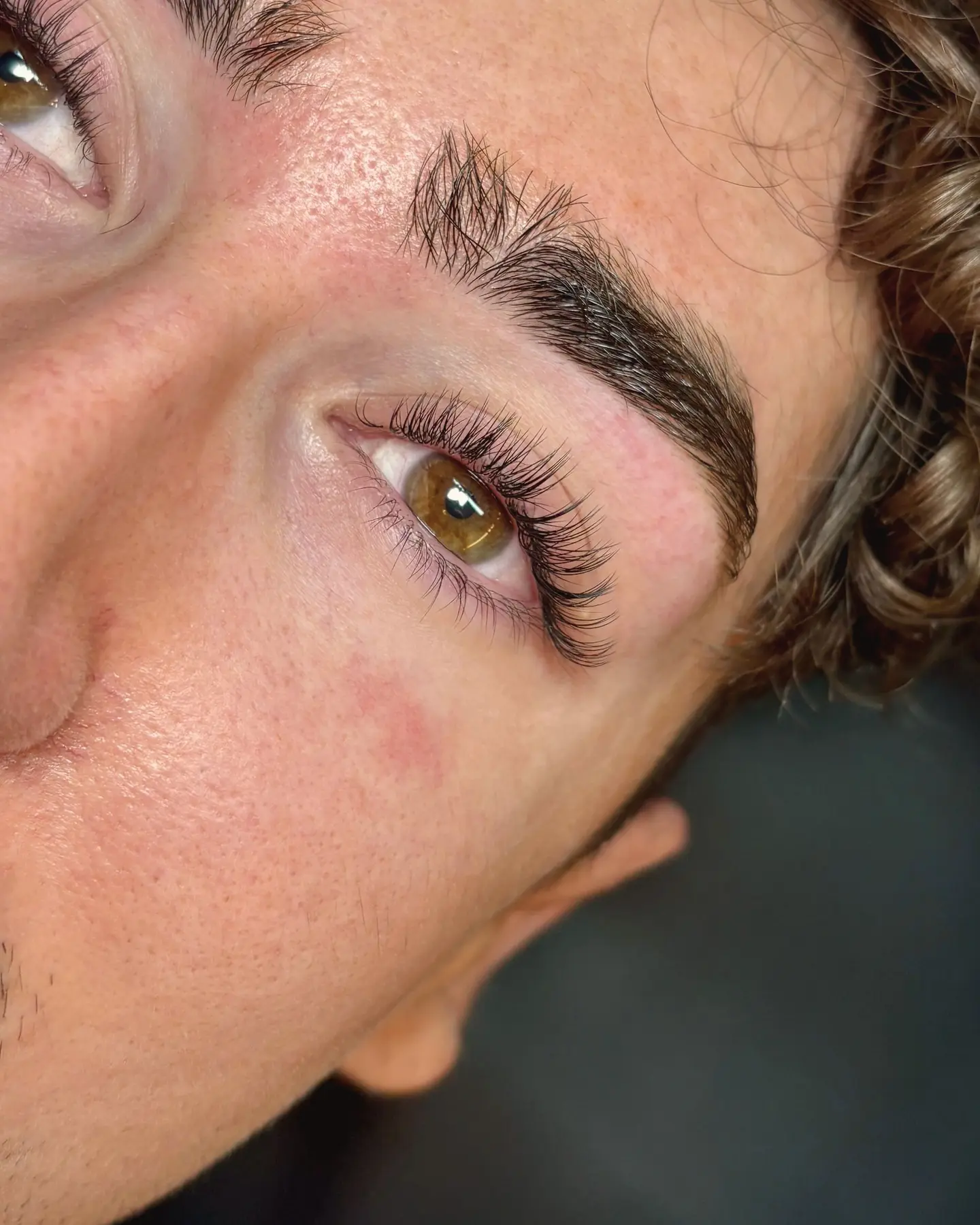 Cils travaillés sur un regard noisette encadré de boucles