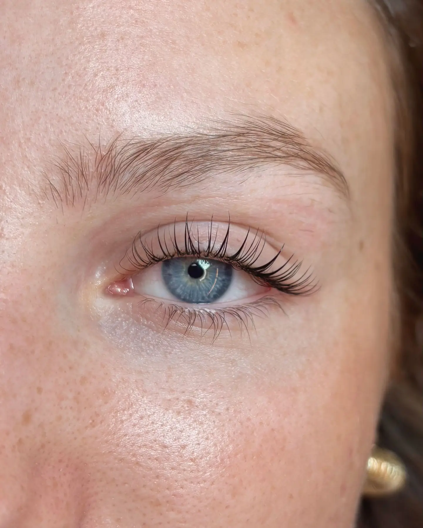 Œil bleu et taches de rousseur, cils rehaussés