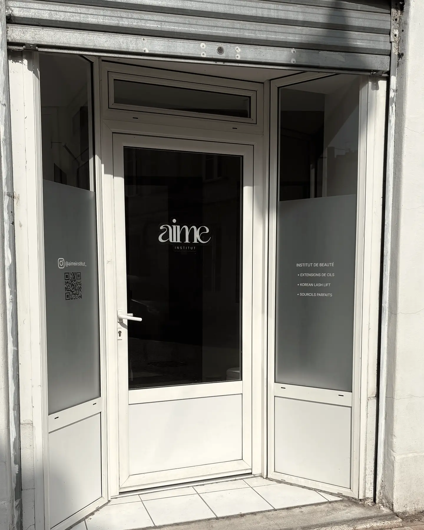 Façade et porte vitrée d'Aime Institut avec le logo, rue Saint-Étienne à Bordeaux