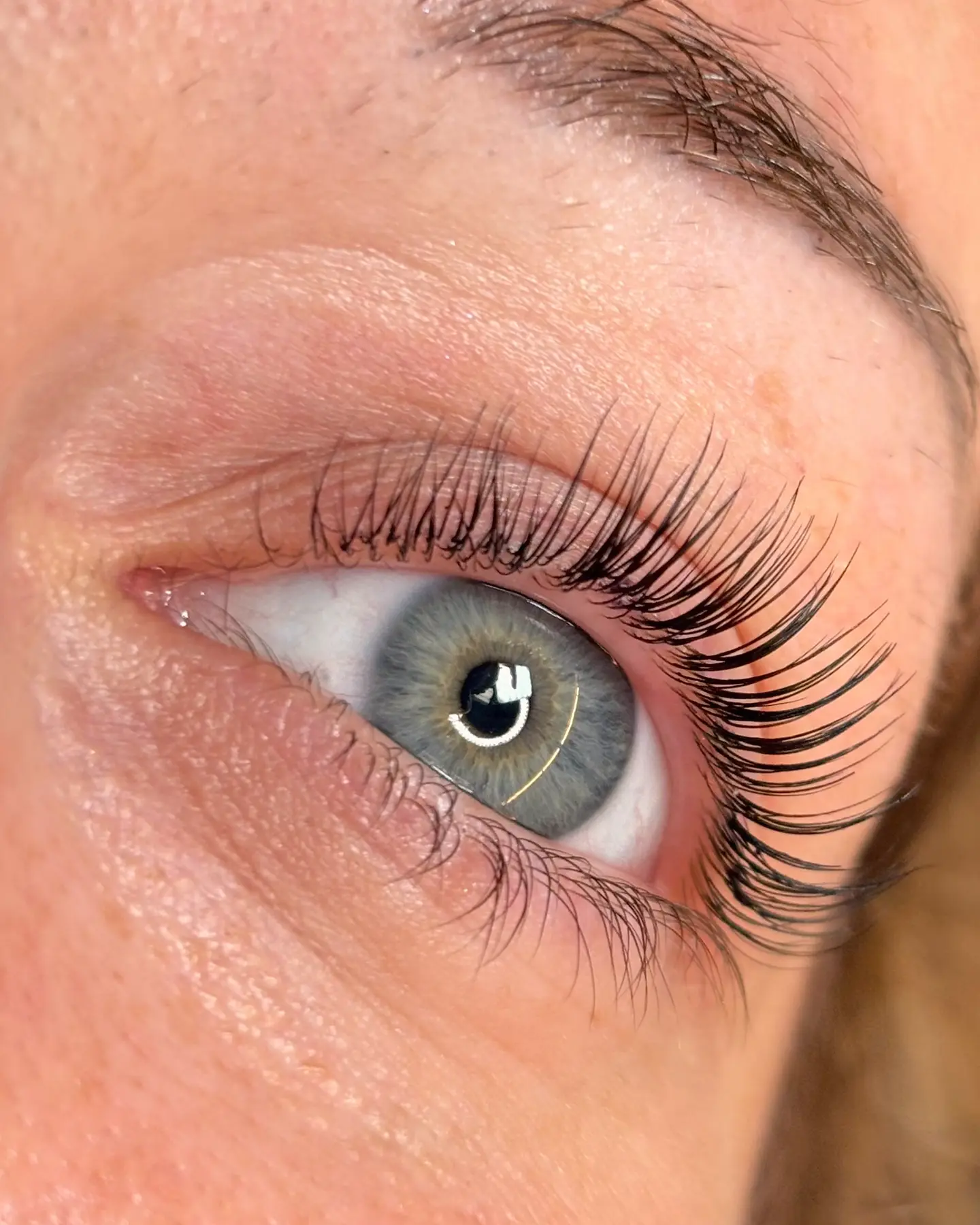 Cils rehaussés sur un œil bleu, vus de trois quarts